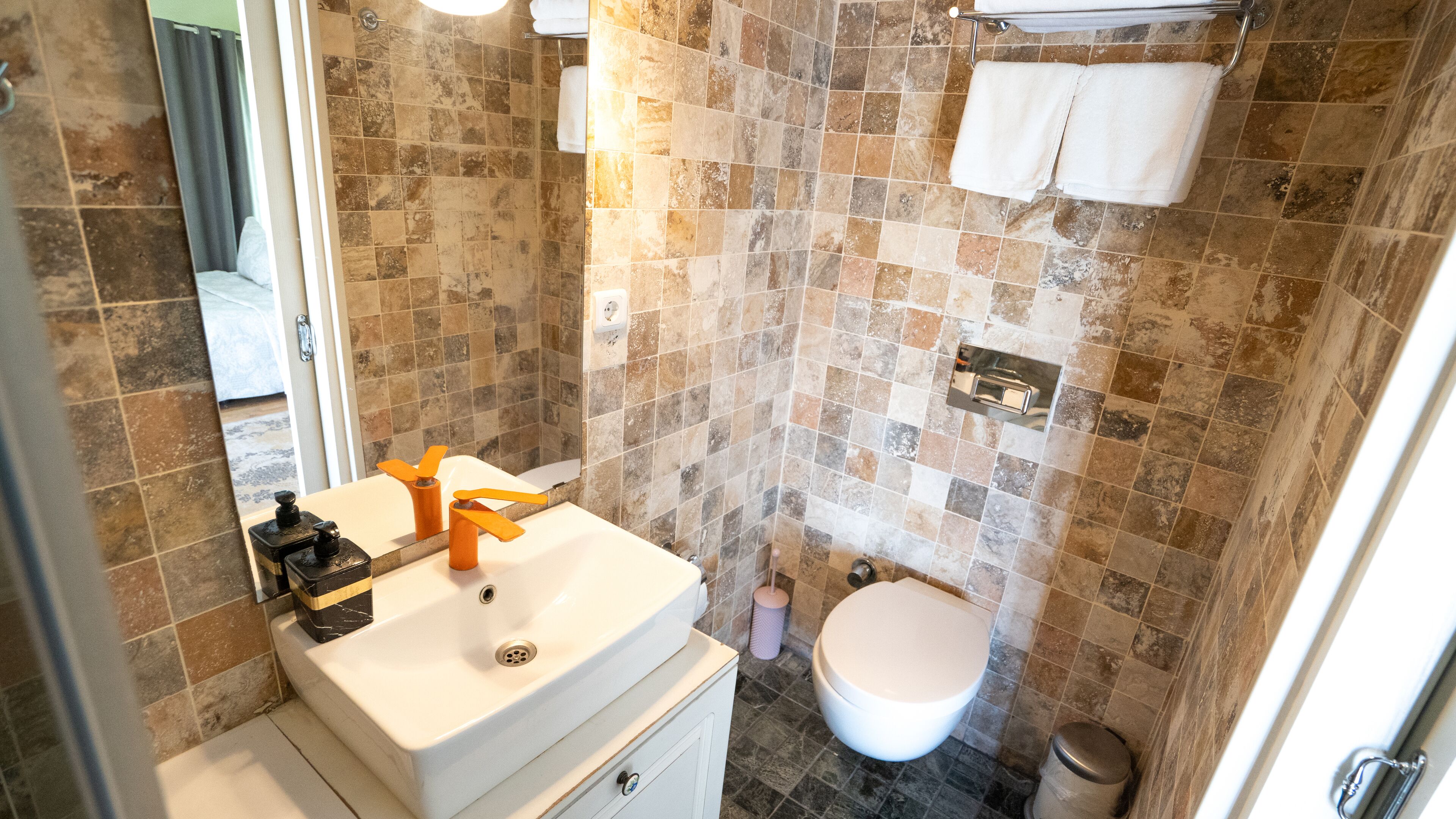 Un baño con lavabo, espejo e inodoro.