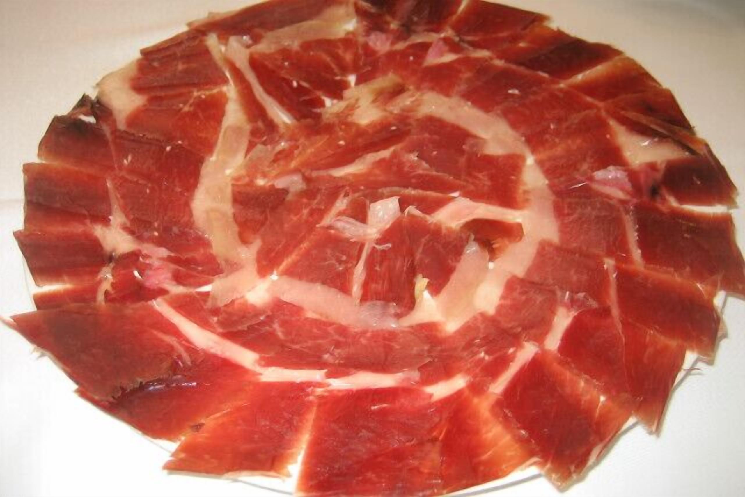 A round platter of sliced cured meat.