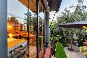 Enjoy casual dining with a clear view through large windows, surrounded by lush greenery and a modern interior.