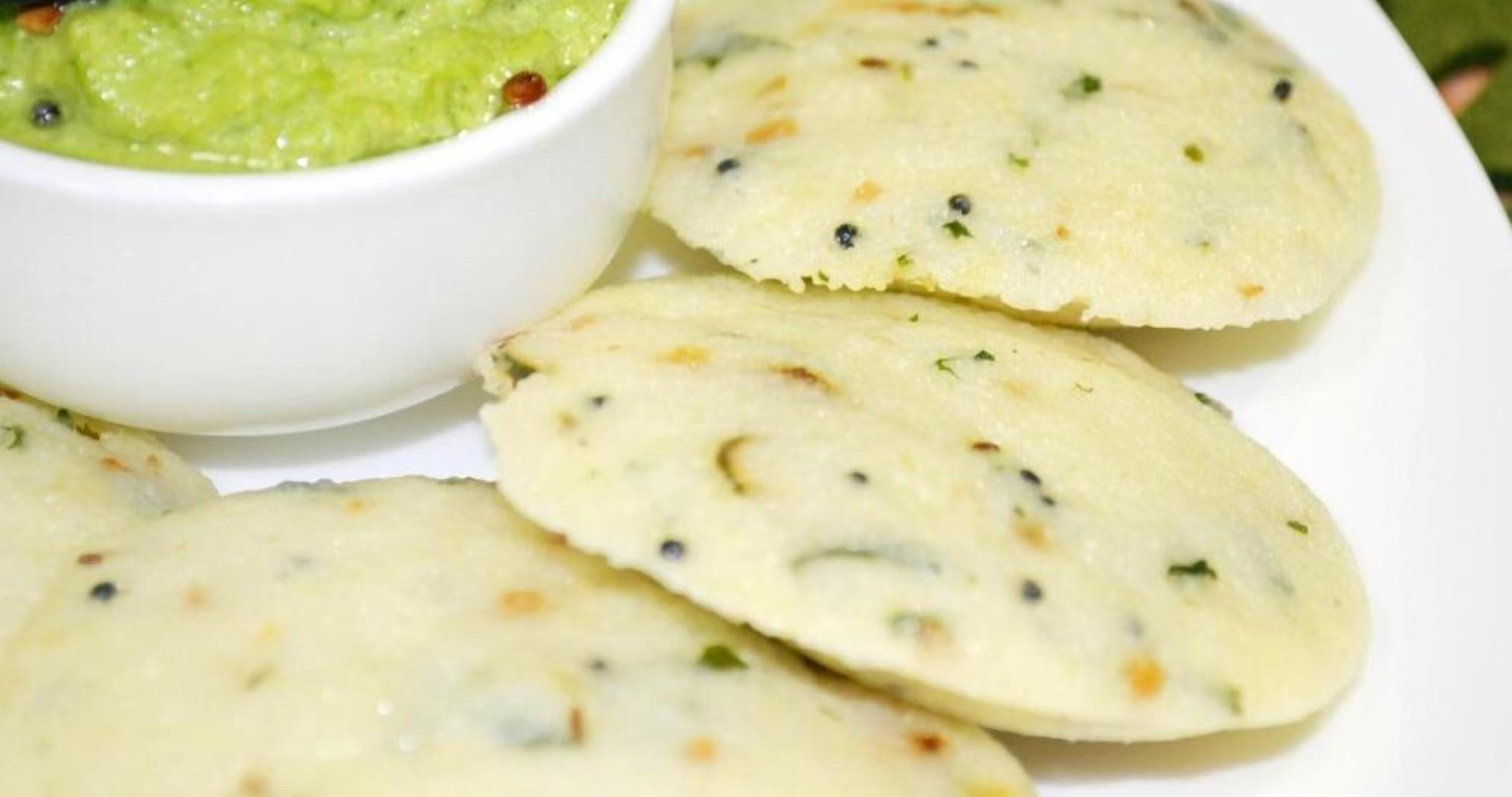A white plate with several pieces of flatbread and a bowl of green dip.