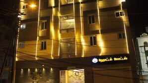 A multi-story hotel with illuminated vertical lines and a sign reading "HOTEL LOTUS". - Hotel Lotus (Madurai)
