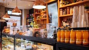 A bakery display case with various baked goods and a selection of juices. - Bayers Boardinghouse & Hotel (Munich)