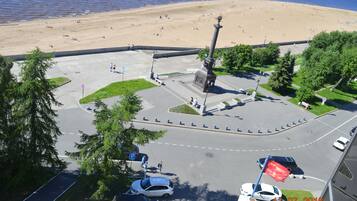 Stroll through the well-maintained park surrounding a historic monument, with the beach and ocean views in the background.