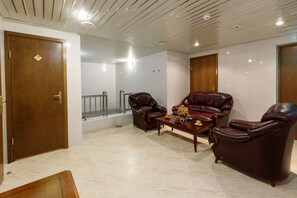 Relax in a stylish room with a leather sofa, coffee table, and glass shower enclosure.