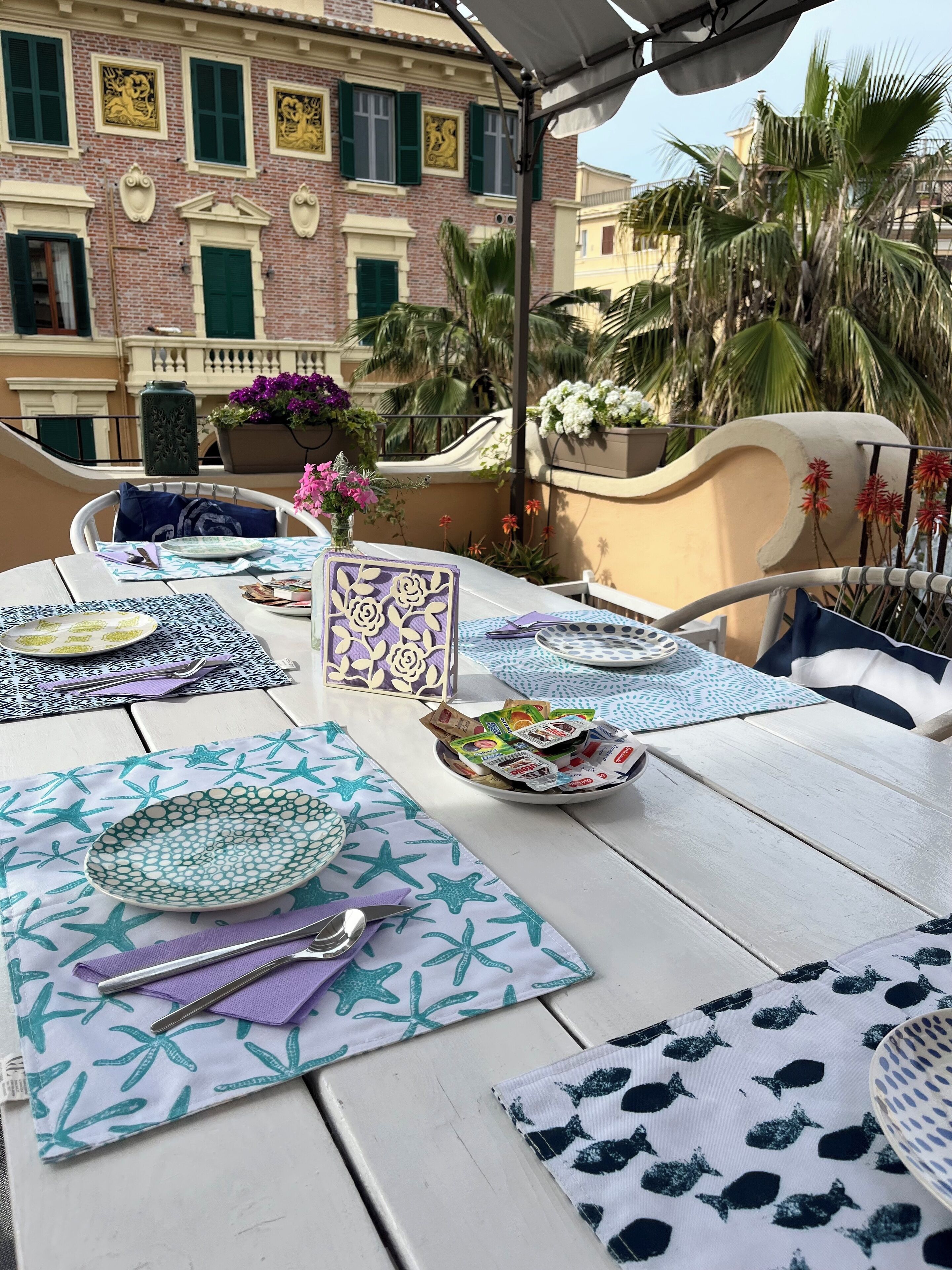 A table set with plates, cutlery, and a bowl of snacks, with a decorative card and a patterned table runner.