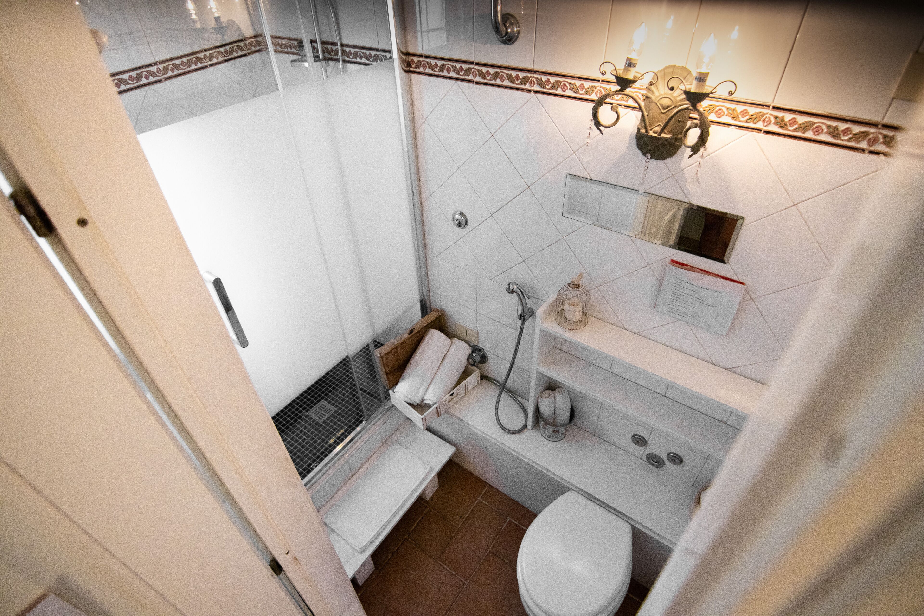 A small, compact bathroom with a shower, toilet, and sink.