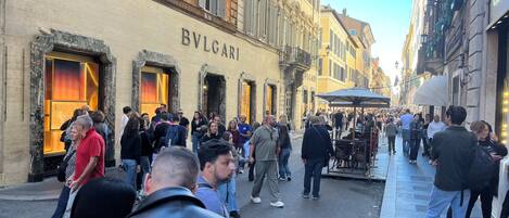 A busy street with a BVLGARI store on the left.