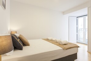 Relax in a serene space with a large bed, a nightstand, and a window offering a view of the outside.
