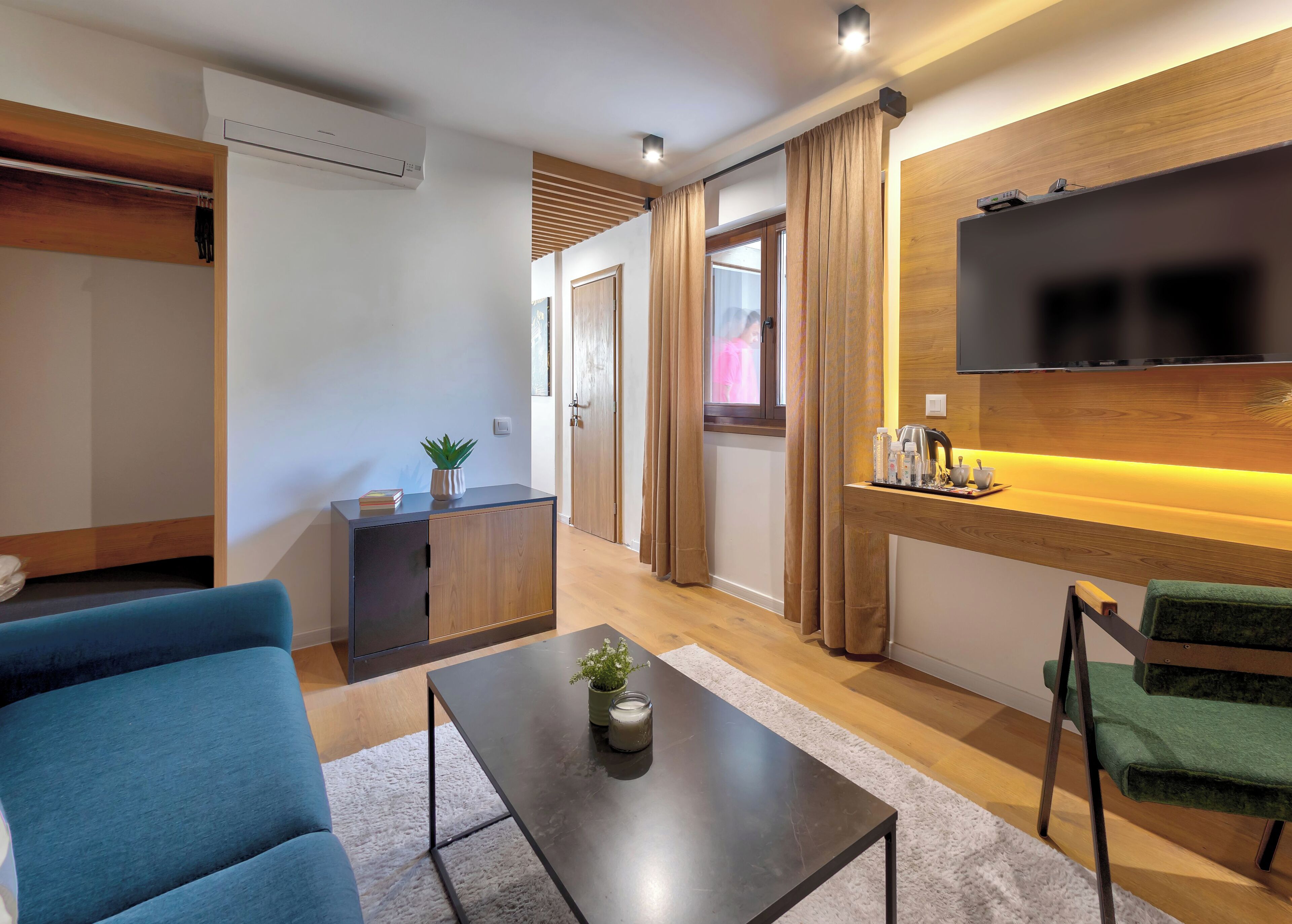 A modern living room with a sofa, a coffee table, and a TV mounted on the wall.