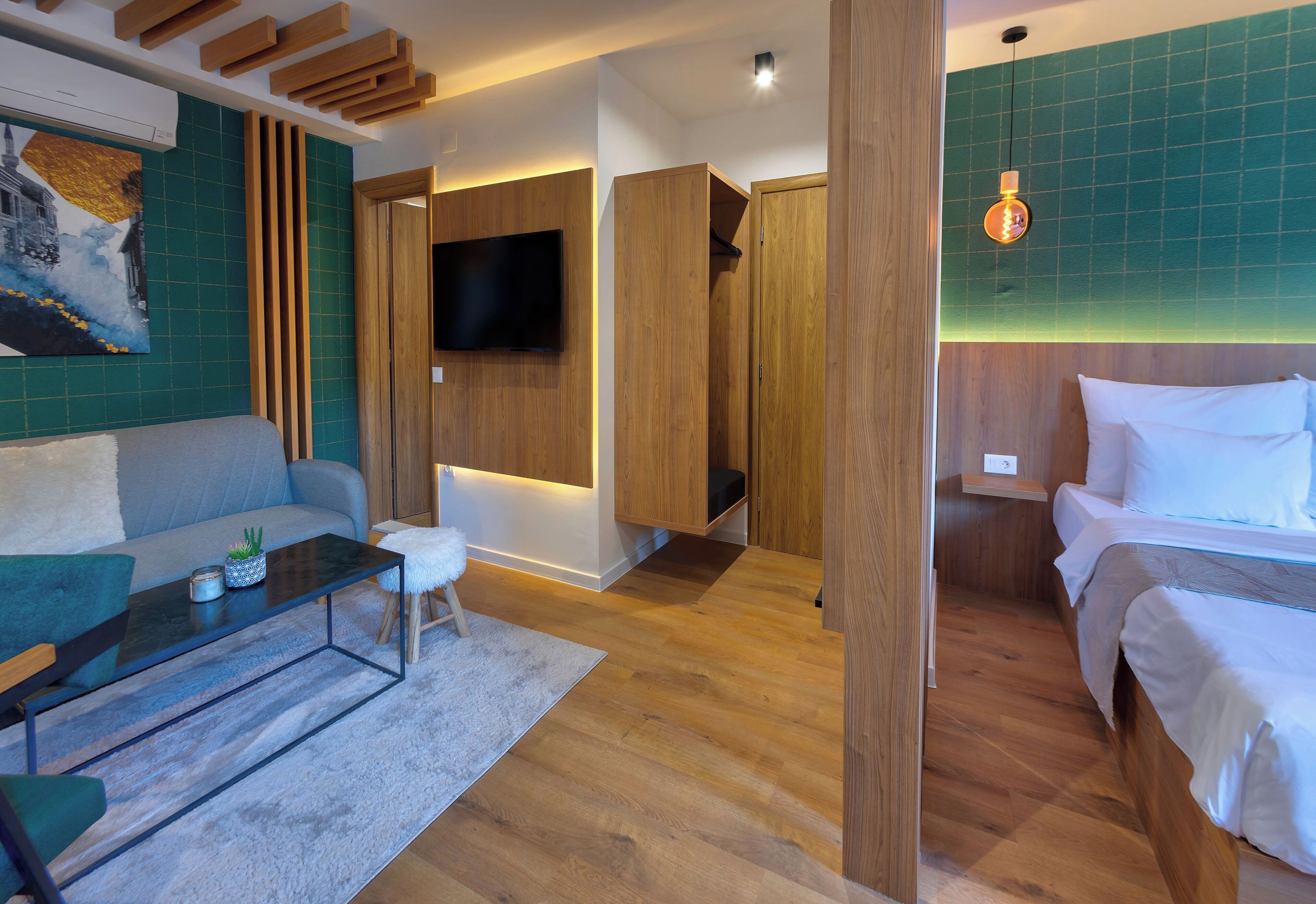 A modern room with a sofa, a bed, a TV, and a wooden cabinet.