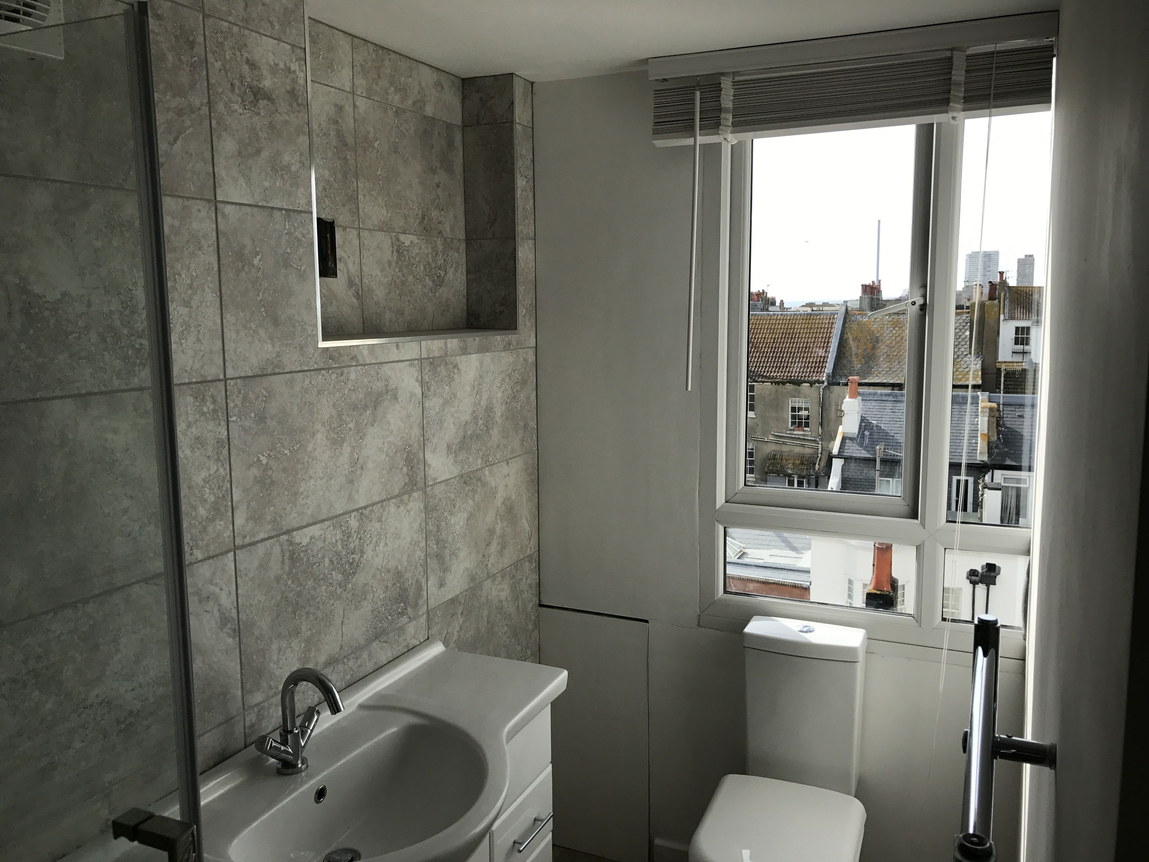 Un baño con lavamanos, inodoro y ventana.