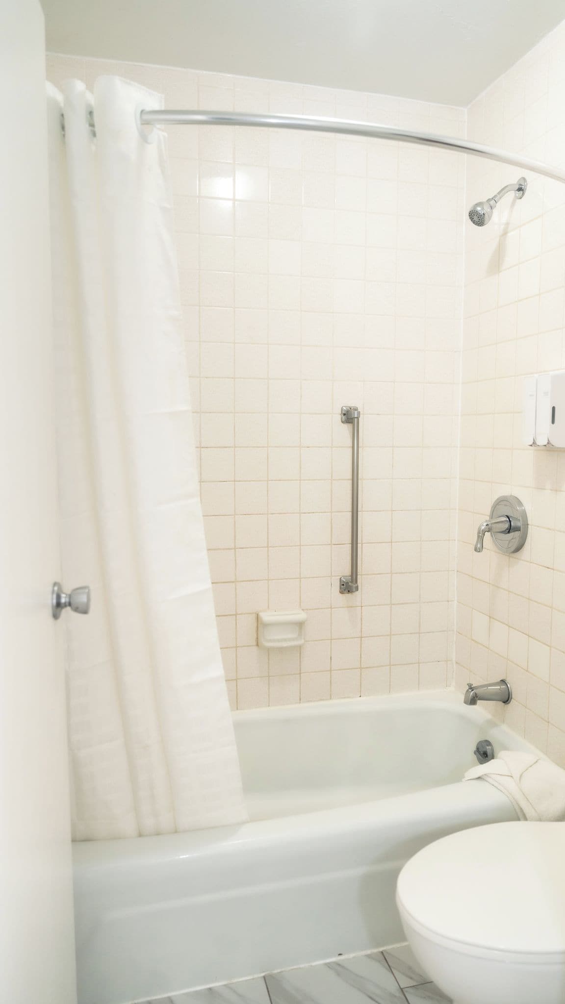 Un baño con bañera, ducha, inodoro y lavamanos.
