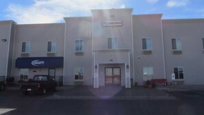 Un hotel de varios pisos con fachada plana, una entrada central y un letrero que dice 'Reddy Hotel'.