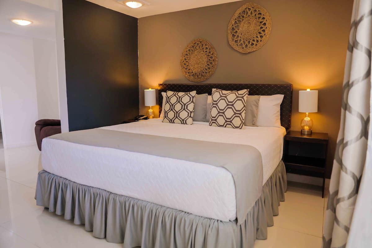A neatly made bed with patterned pillows, two wall-mounted decorative items, and bedside lamps.