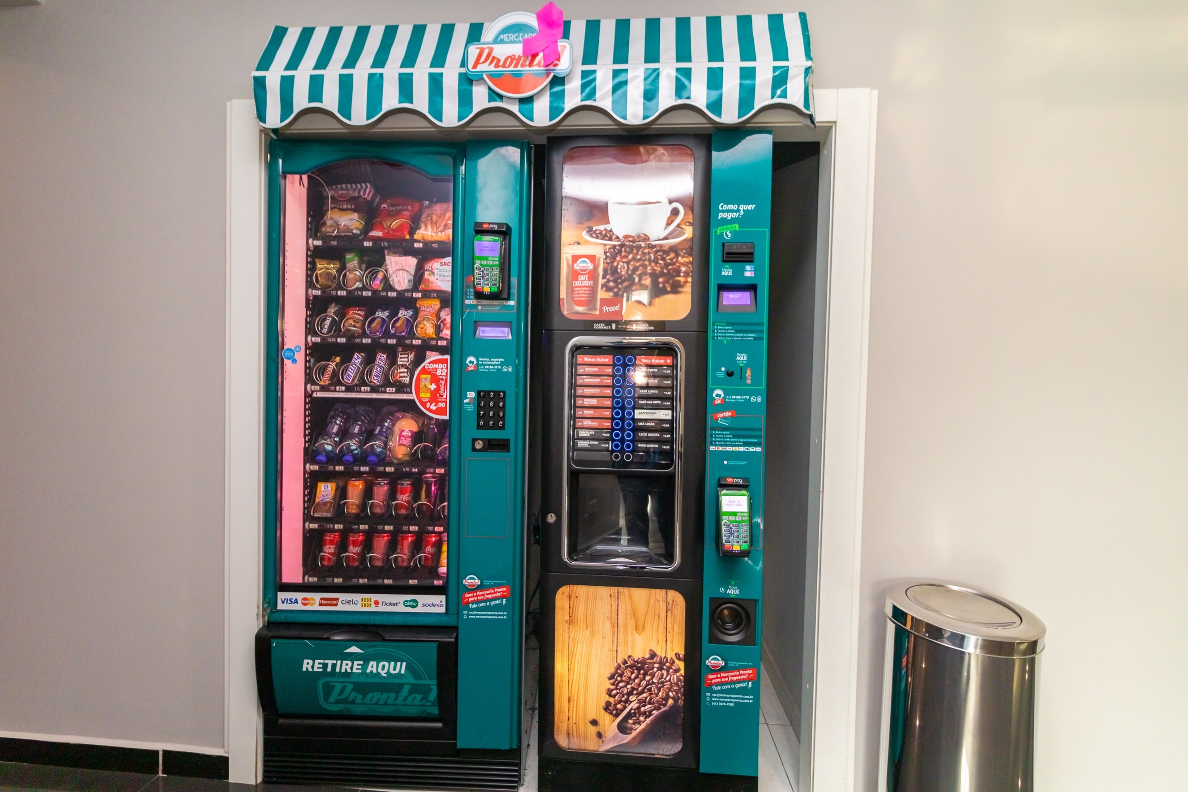 Een automaat met een advertentie voor koffie en een bordje 'Retire Aqu'.