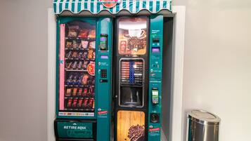 Een automaat met een advertentie voor koffie en een bordje 'Retire Aqu'.