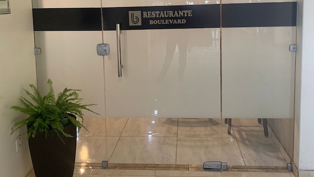 Une entrée moderne avec une porte en verre et une enseigne indiquant « RESTAURANT BOULEVARD ».