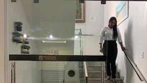 Un intérieur moderne avec une entrée en verre, un escalier et un panneau indiquant « Boulevard, parking relais ».