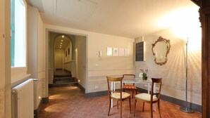 Uma área de refeições com mesa e cadeiras, um espelho e um radiador.