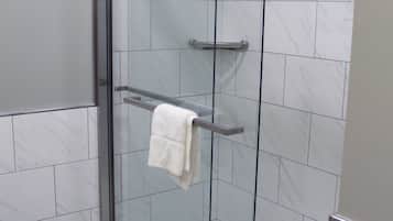 A glass-enclosed shower with a towel rack and a glass door.