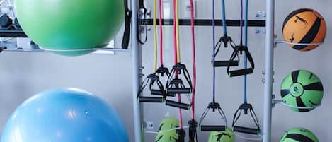 Un gimnasio con pelotas de ejercicio, bandas de resistencia y colchonetas de yoga.