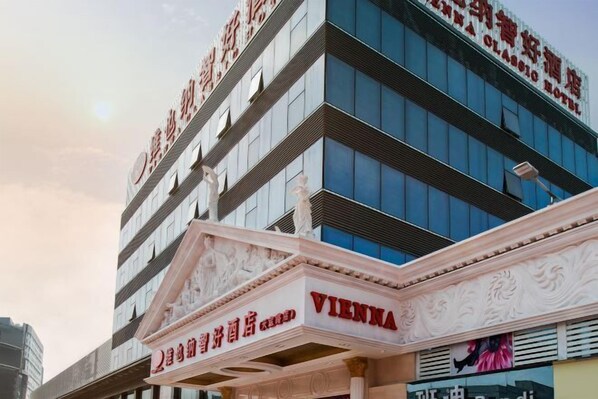A multi-story building with a prominent "VIENNA" sign on the facade. - Vienna Hotel (Shenzhen Tianbao Road) (SHENZHEN)