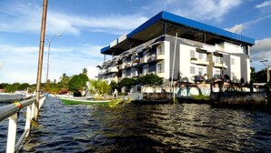 Un immeuble à plusieurs étages doté de balcons, situé près d’une étendue d’eau.