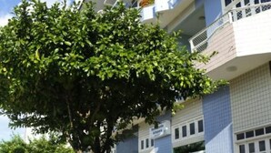Un bâtiment à l’architecture moderne, doté de balcons ornés de plantes et d’un banc situé au premier plan.