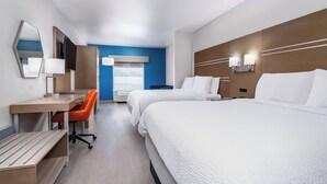 Habitación de hotel con dos camas, un escritorio, una silla y un televisor.