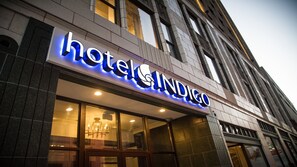 A hotel sign with illuminated letters, a large glass entrance, and a classic building facade. - Hotel Indigo Kansas City Downtown by IHG (Kansas City)