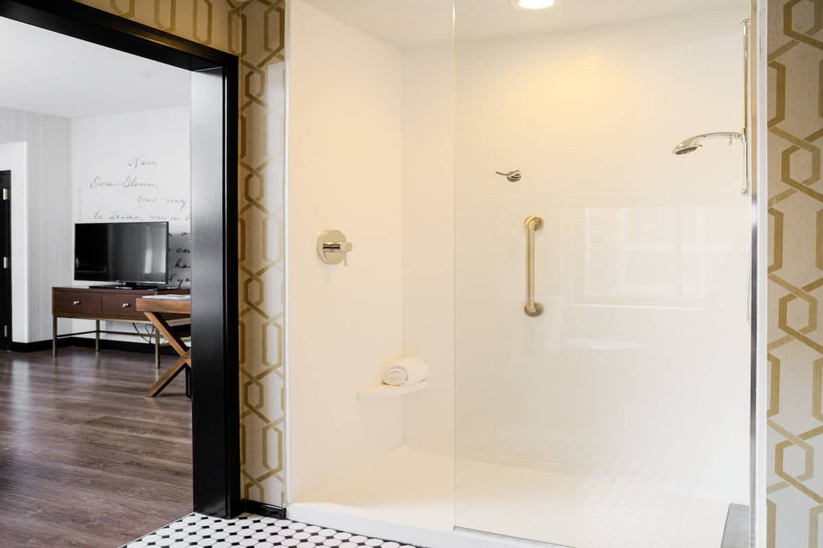 A modern bathroom with a glass shower enclosure, a toilet, and a sink.