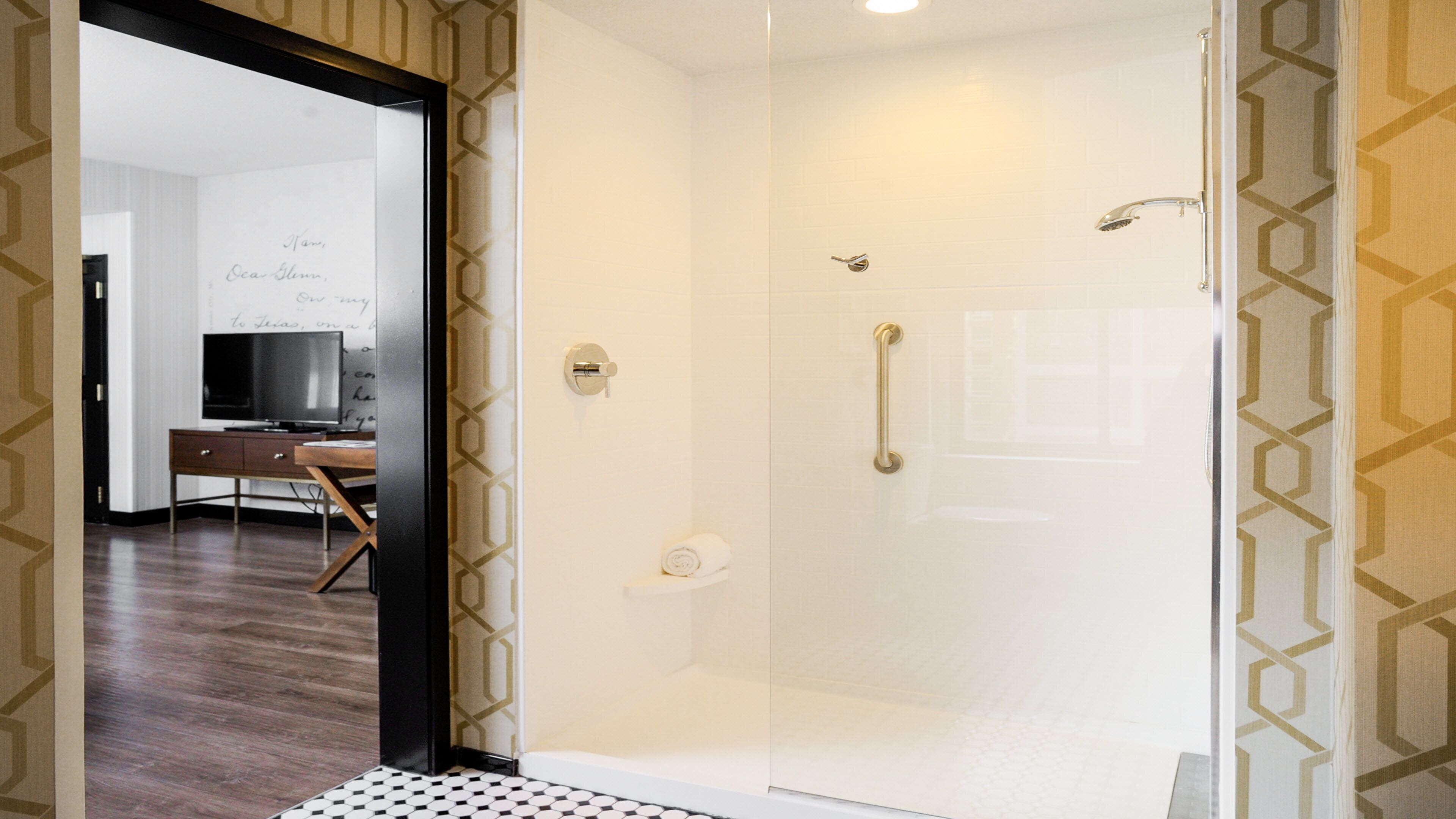 A modern bathroom with a glass shower enclosure, a towel rack, and a toilet.