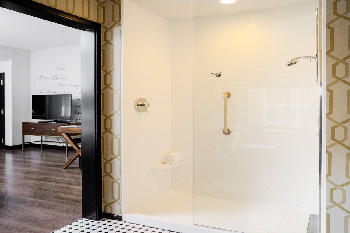 Ein modernes Badezimmer mit Duschkabine aus Glas, Handtuchhalter und Toilette.