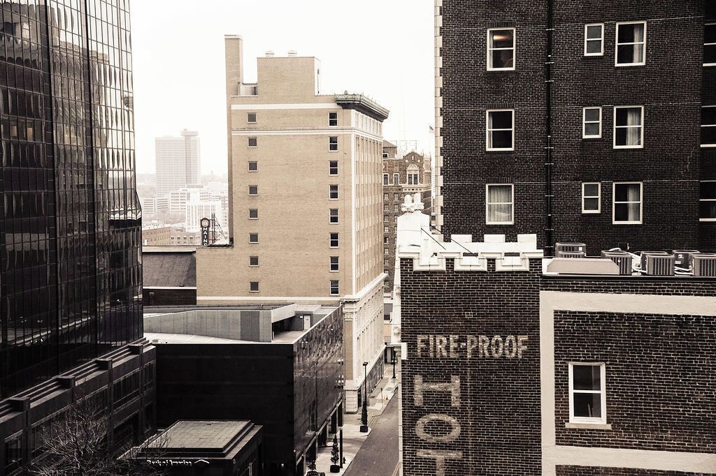 A cityscape with a building labeled 'FIRE-ROOF HOTEL' and a modern glass building.