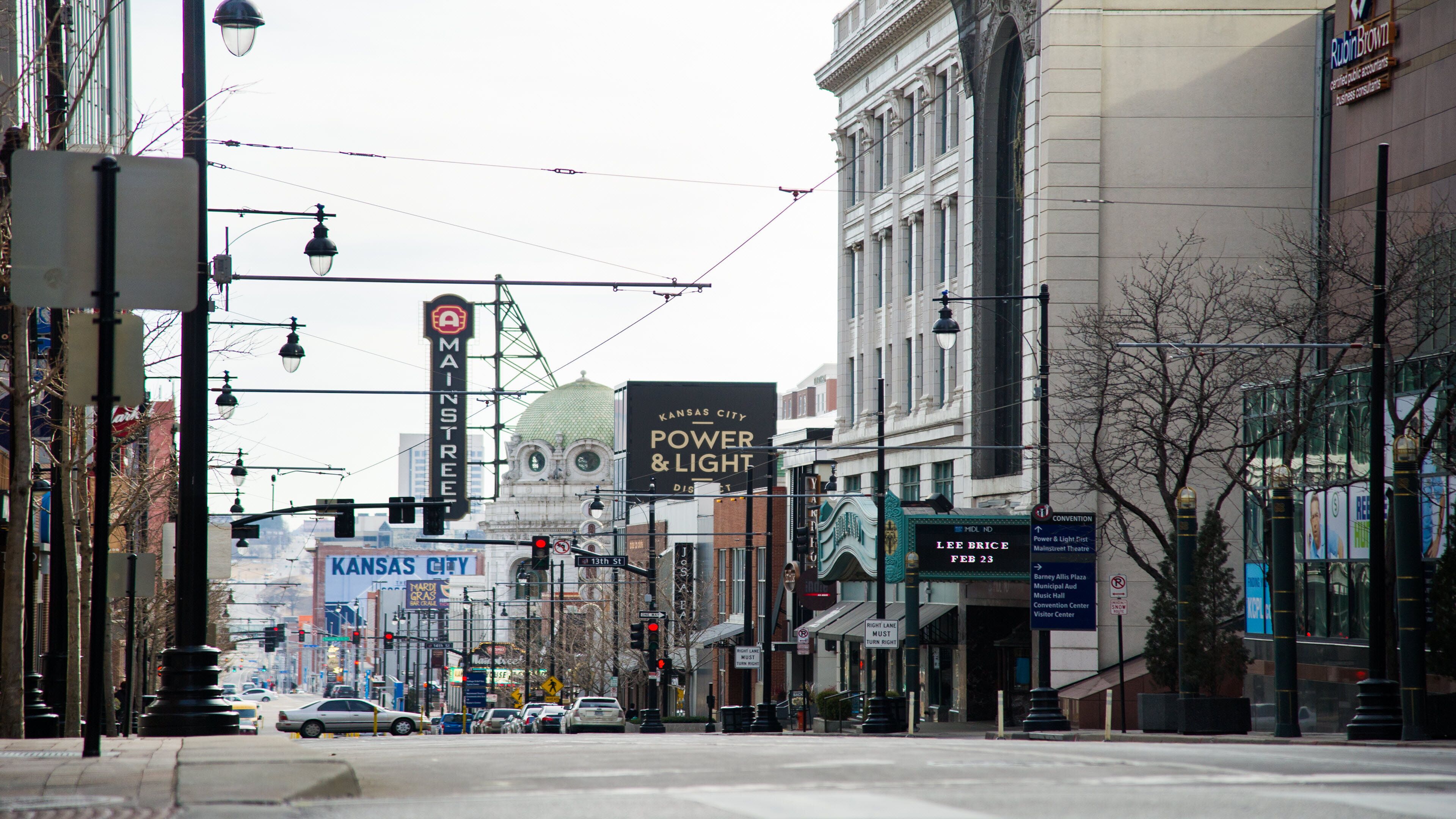 Une vue de rue avec des bâtiments, des feux de signalisation et une enseigne indiquant l’emplacement du Main Street Theatre.