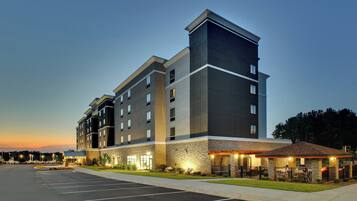 A multi-story hotel with a parking lot in front.