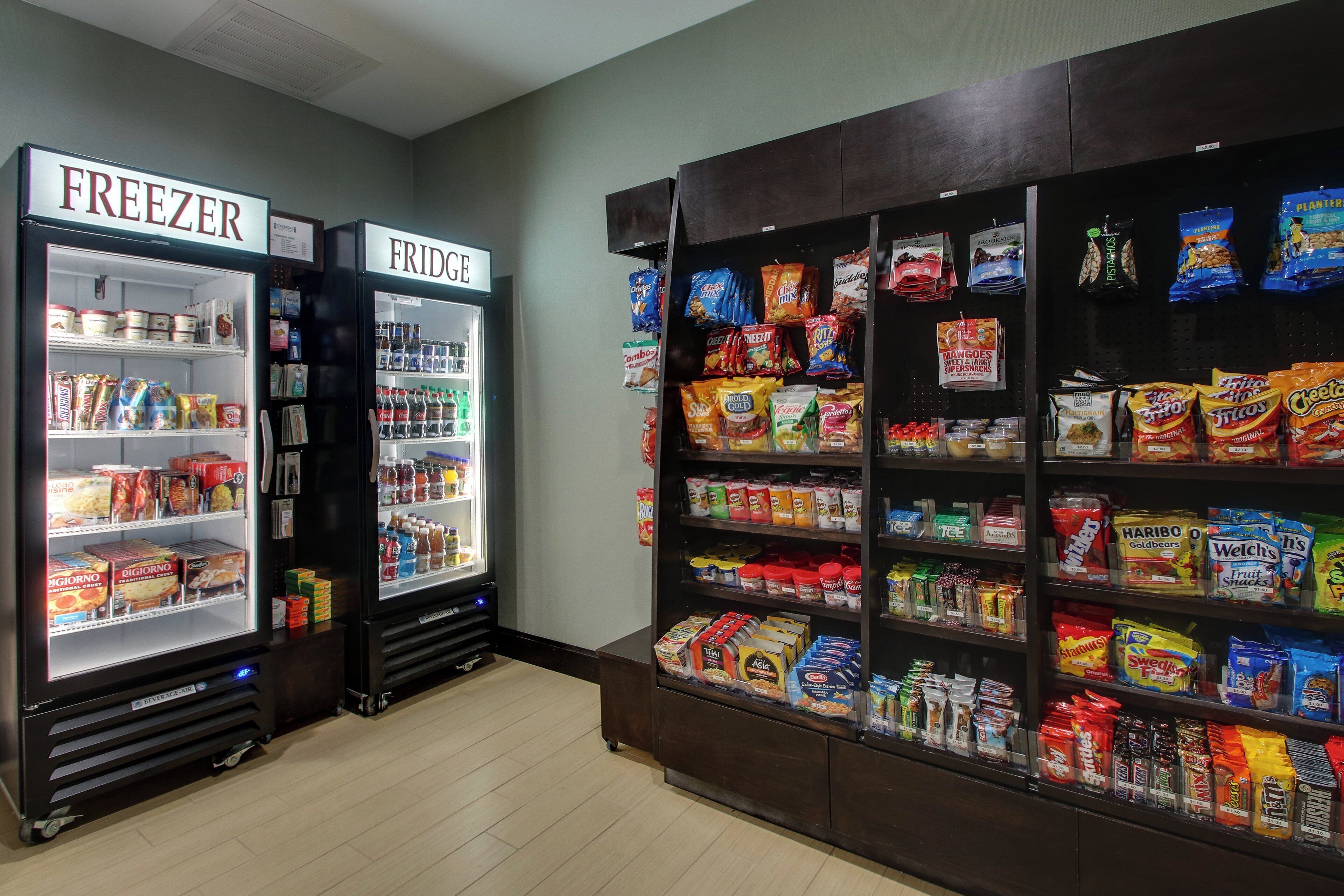 A freezer and a truck vending machine with a variety of snacks and beverages.