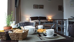 Ein Hotelzimmer mit Essbereich, einem Bett, einer Küche und Blick ins Freie.