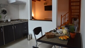 Eine moderne Küche mit dunklen Schränken, einer Arbeitsplatte aus Granit und einem Essbereich mit gedecktem Tisch für das Frühstück.