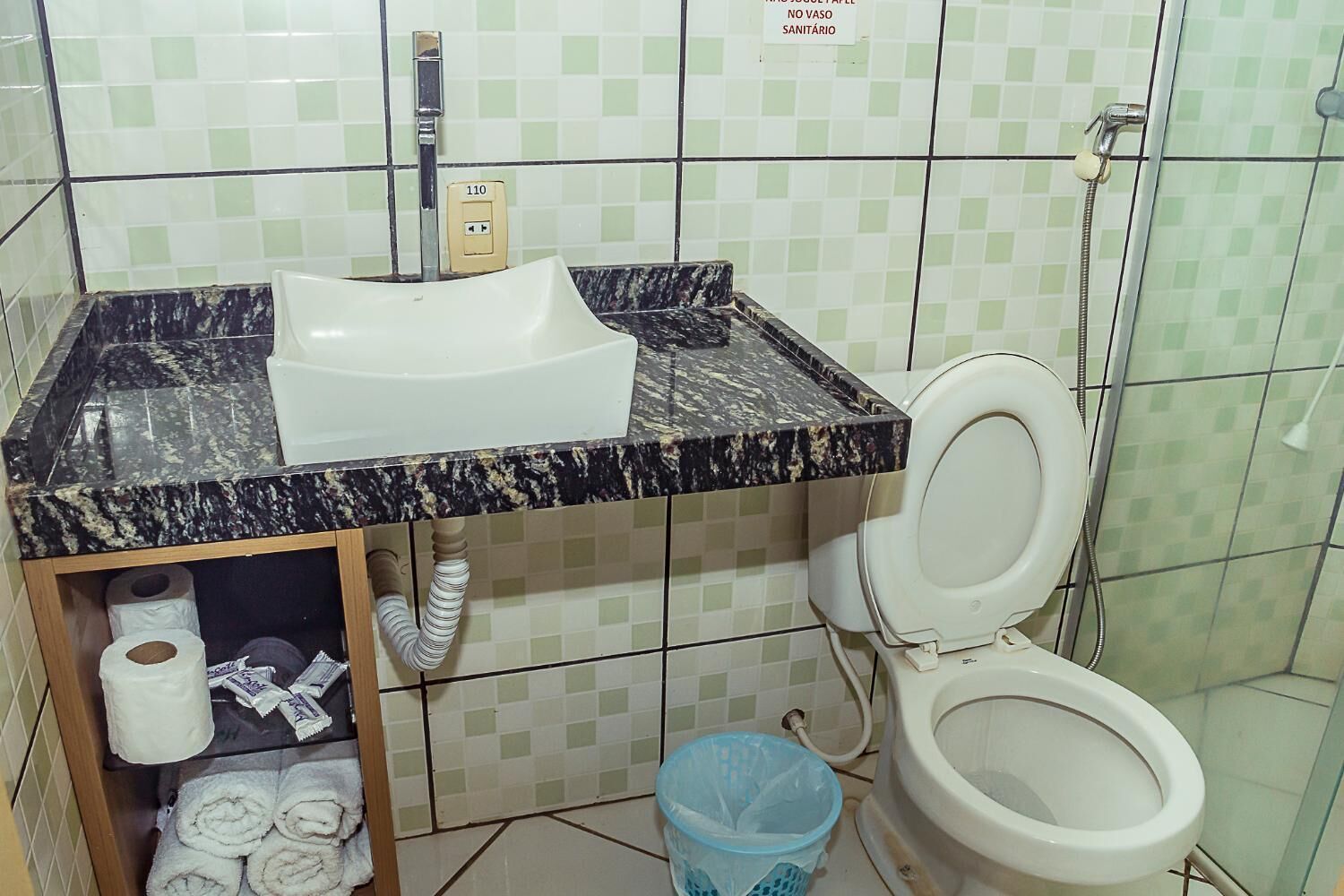 Un baño con lavamanos, inodoro y ducha.