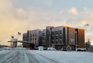 A Marriott hotel with a modern design, featuring a prominent entrance and a parking area.