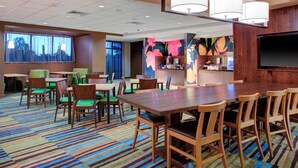 A hotel conference room with a large table, chairs, and a TV screen. - Fairfield Inn & Suites by Marriott Flagstaff Northeast (Flagstaff)