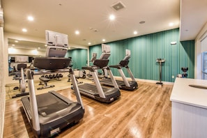 A gym with treadmills, a rowing machine, and a weight bench. - Holiday Inn Express & Suites Dallas NW - Farmers Branch by IHG (Farmers Branch)