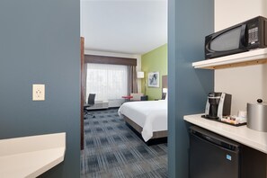 A hotel room with a bed, a desk, a microwave, a coffee maker, and a mini-fridge. - Holiday Inn Express & Suites Dallas NW - Farmers Branch by IHG (Farmers Branch)