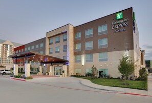 A Holiday Inn Express hotel with a covered entrance, multiple floors, and a brick facade. - Holiday Inn Express & Suites Dallas NW - Farmers Branch by IHG (Farmers Branch)