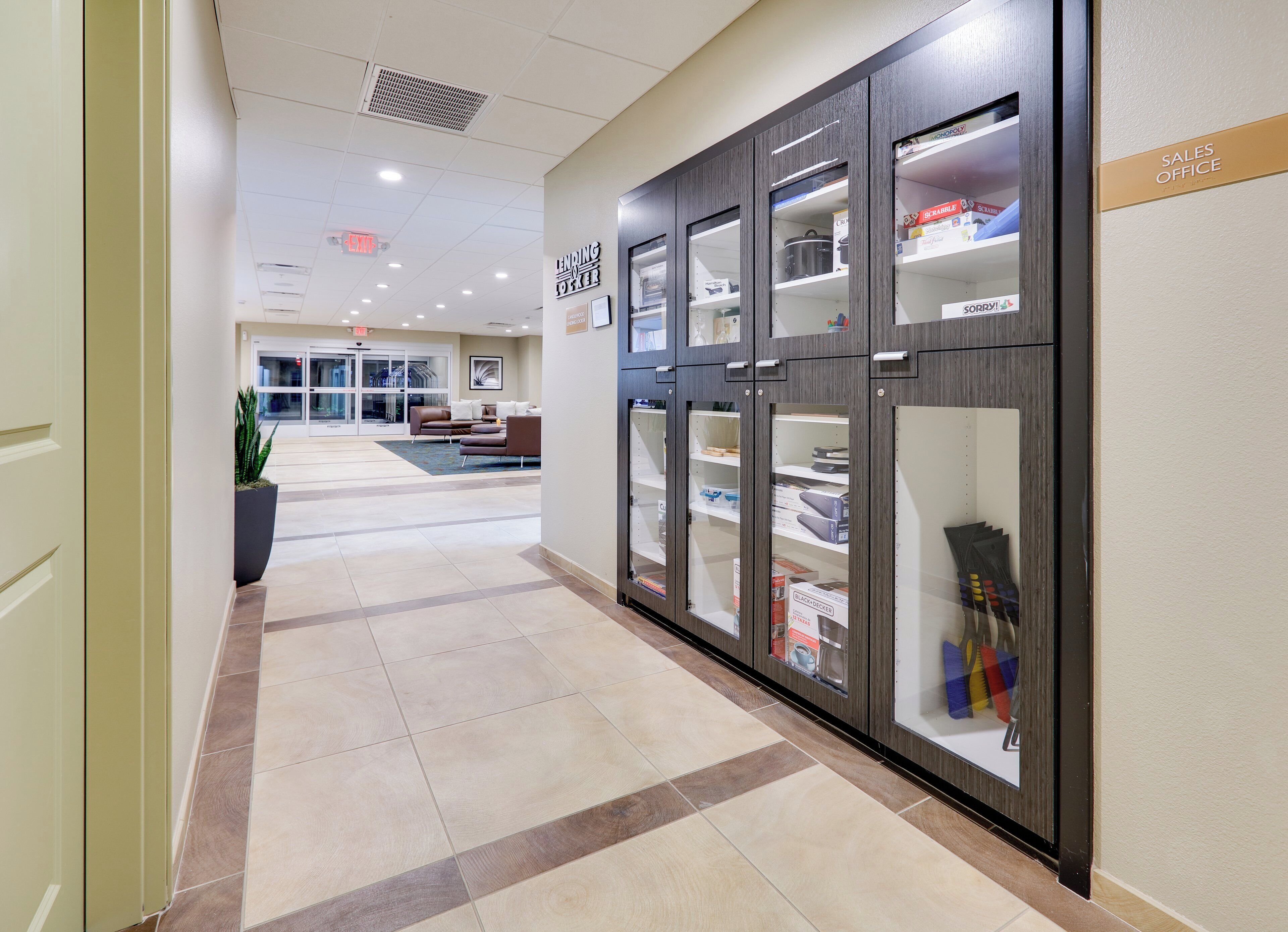 A hotel corridor with a reception area, a seating area, and a sales office.