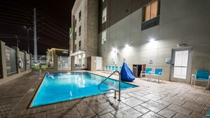 An indoor swimming pool with a tiled floor, a metal pool ladder, and blue chairs around the pool area. - Holiday Inn Express & Suites Lake Charles South Casino Area by IHG (Lake Charles)