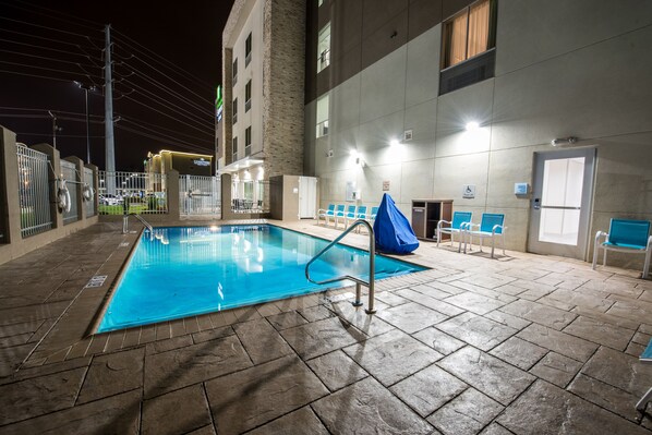 An indoor swimming pool with a tiled floor, a metal pool ladder, and blue chairs around the pool area. - Holiday Inn Express & Suites Lake Charles South Casino Area by IHG (Lake Charles)