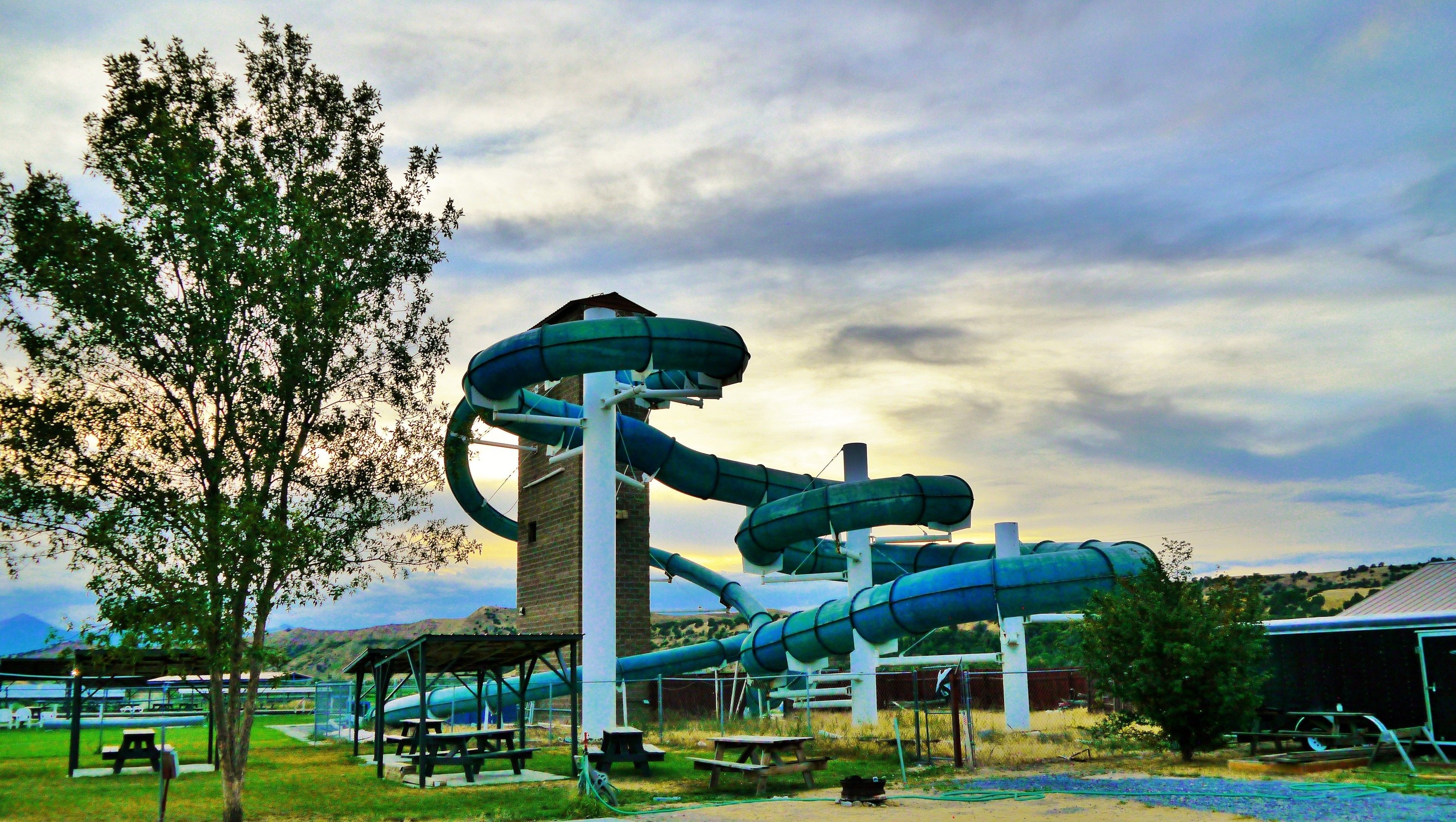Un parque acuático con toboganes y mesas de picnic.
