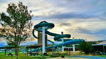 Un parque acuático con toboganes y mesas de picnic.